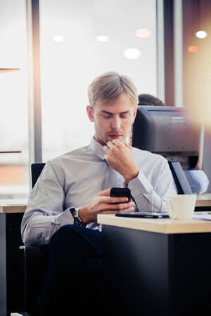 People working on laptop at their desk with manager supervising the work. Business people working in a small office.の写真素材