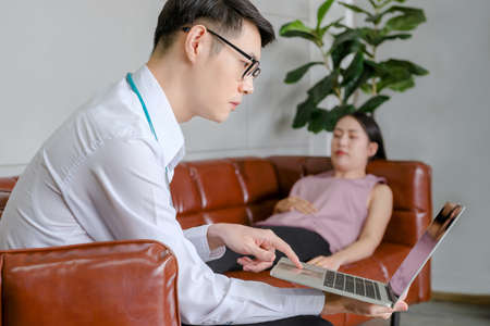 mental people concept. The young doctor's psychologist is working on a notebook See reports of female mental patients at workの写真素材