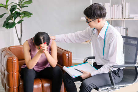 female mental concept. The young doctor's psychologist is talking with a mental patient woman at officeの写真素材