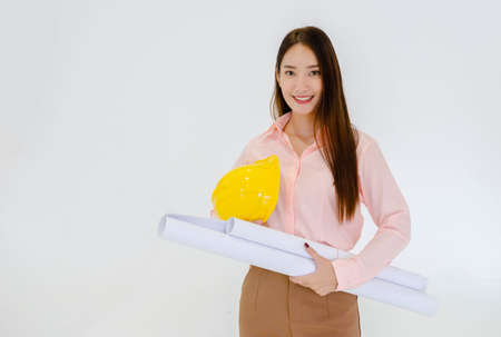 Female architect standing with a hat and working structure chart on a white groundの写真素材