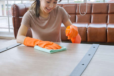 Women clean the house with clothes and liquid. To protect against viruses, Corona Covid-19 prevents the spread of the virus.の写真素材