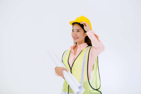 Female architect standing with a hat and working structure chart on a white groundの写真素材