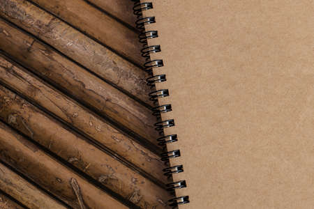 Closed Brown note book on a bamboo background, simple textureの写真素材