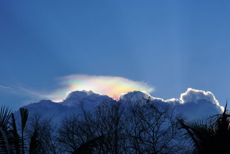 Blue sky with clouds under evening sun auraの写真素材