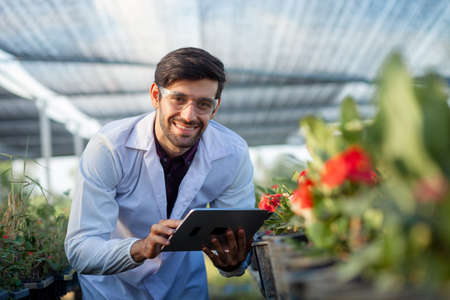 Portrait of an agricultural researcher. flower growth In the Botanical Garden with lots of fresh flowers and other plantsの写真素材