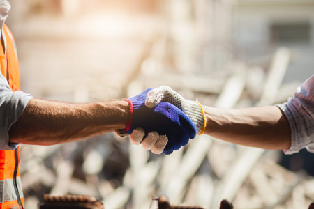 Close-up Architects shaking hands with construction workers after a successful background meeting on...