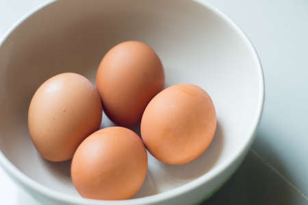 fresh brown eggs in bowlの写真素材