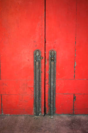 old iron lock with bolt on the red door found in a temple in Thailandの写真素材