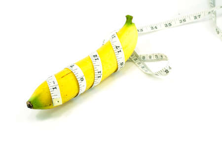 Large banana and measuring tape on a white backgroundの写真素材