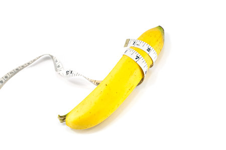 Large banana and measuring tape on a white background