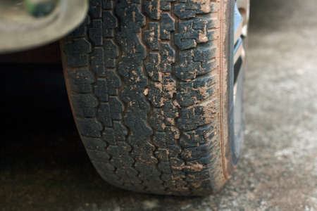 a weathered car wheel with mud and dirtの写真素材