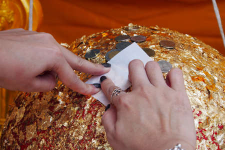 Thai tradition cover statue of Buddha with gold leaf and Hands were gildedの写真素材