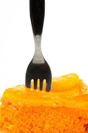 Orange cake with fork on white plateの写真素材