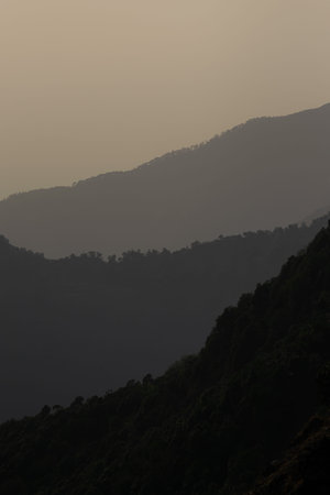 different shades of layers of mountain on a smoggy day during sunset