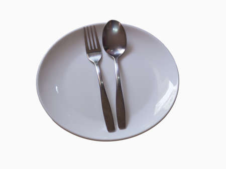 A spoon rests on a white plateの写真素材