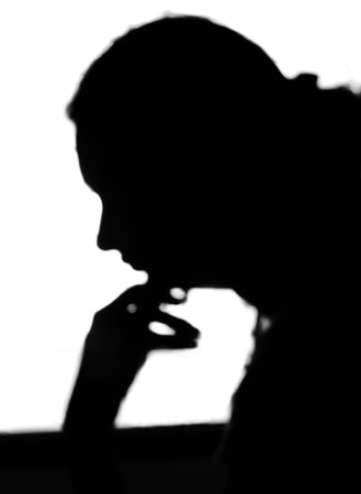 Black and white sideways head and shoulder silhouette portrait of an isolated girl