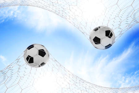 Soccer football in Goal net with Blue skyの写真素材