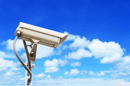 Security camera on blue sky background