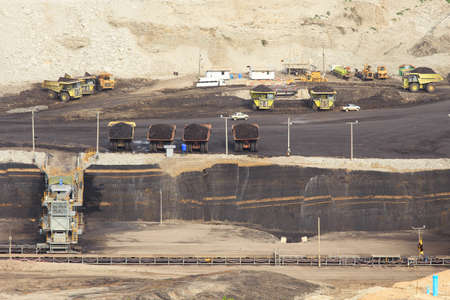 Coal mining in an open pit with huge industrial machineの写真素材