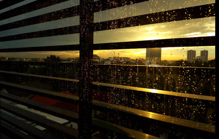 View of a city from the corner of the building.And there are drops on the glass,stunning sunlight.