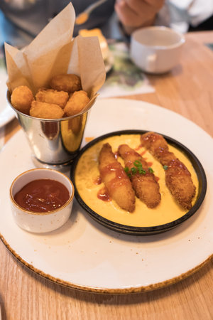 Meal time. Let's have chicken sticks, corn and cheese, hash brown and tomato sauce.