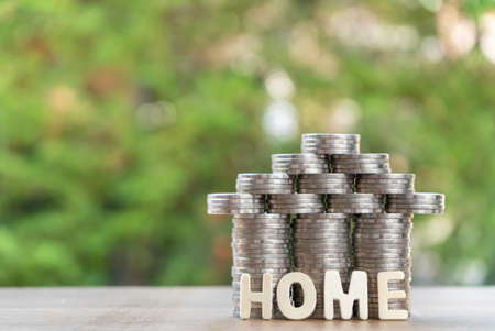 coin stack with house model, home message, savings plans for housing ,green background, financial conceptの写真素材