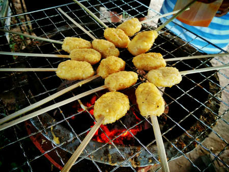 Grilling rice stick over the fireの素材