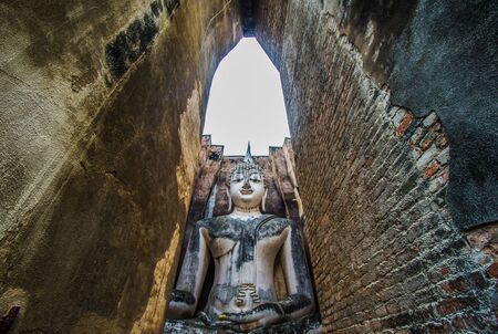 Sukhothai Historical Park  Thailand  traveller with ancient Buddha statue at Wat Si Chum temple.の写真素材