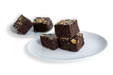Homemade dark chocolate fudge brownie cake topped with sliced ââalmond slices on white background.の写真素材