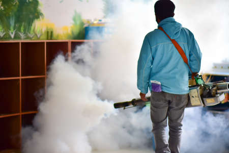 Workers spray mosquito pesticides with a motorized sprayer.の写真素材