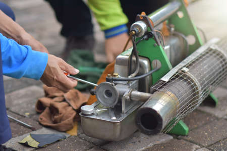 The mechanic is repairing the machine - spraying mosquitoes to prepare for mosquito spray.の写真素材