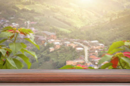 Wooden table and blur of beauty, sunset sky, and mountains as background.の写真素材