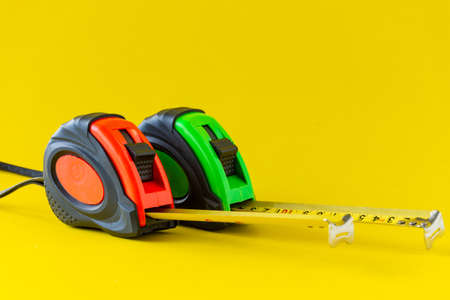 Tape measure on a yellow background, space for text.の写真素材