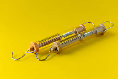 Compact spring balancer with hook Isolated on yellow background.の写真素材
