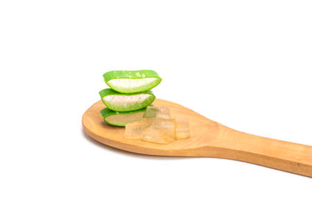 Sliced ââfresh green aloe leaves in wooden spoon isolated on white background. Skincare concept, health and beauty spa.の写真素材