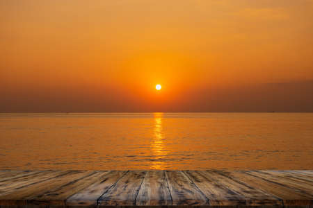 Empty wooden table on beautiful sea sunsetの写真素材
