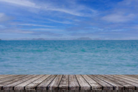 The wooden tabletop on a blurred background of sea and blue sky for displaying or editing your products.の写真素材
