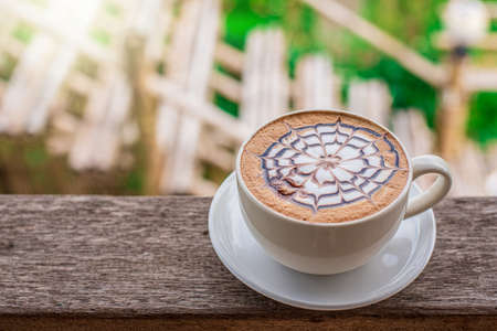 Coffee on a wooden table in a natural background in a warm color gardenの写真素材