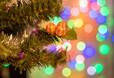 Closeup of balls on Christmas tree. Bokeh garlands in background. New year concept. Festive decoration.の写真素材