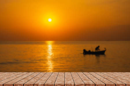 Empty wooden table on beautiful blurred sea sunsetの写真素材