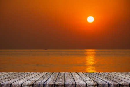 Empty wooden table on beautiful blurred sea sunsetの写真素材