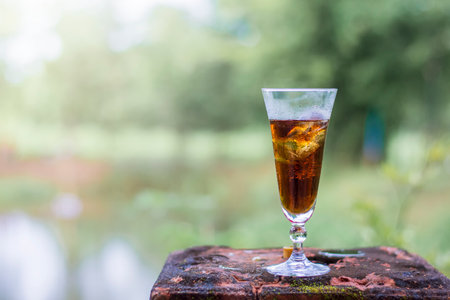 Cola in the glass over sunlight and natural green background cola in a glass with iceの写真素材