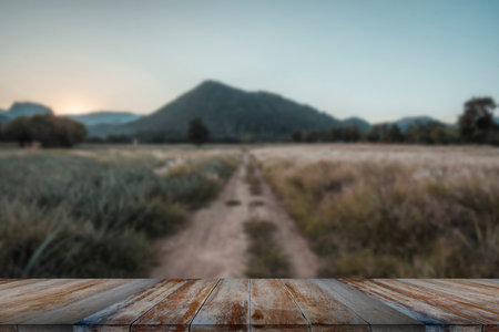 Wooden table and blur of beauty, sunset sky, and mountains as background.