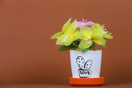 fake flowers in a vase on the table with copy space for designの写真素材