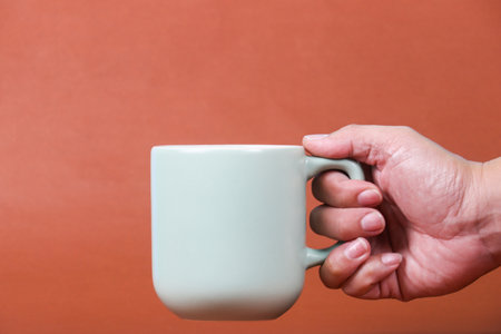 hand holding coffee cup with copy space for design wood grain vintage backgroundの写真素材