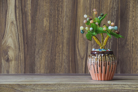 Fake flowers in a vase placed on a table on a wooden table with copy space for design wood grain vintage background.の写真素材