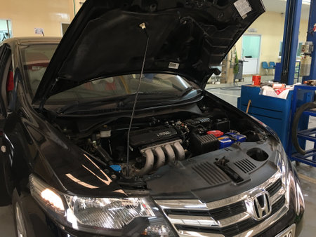 Auto mechanic repairing a car in a car repair shop, closeup of photoの写真素材