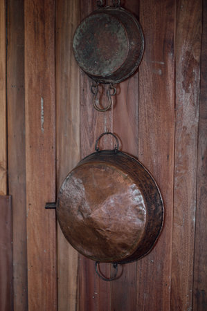 Old rusty pan hanging on the wall of the old house in Thailandの写真素材