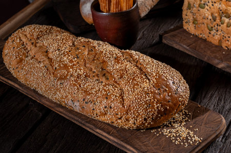Whole wheat bread with sesame seeds on a wooden board.