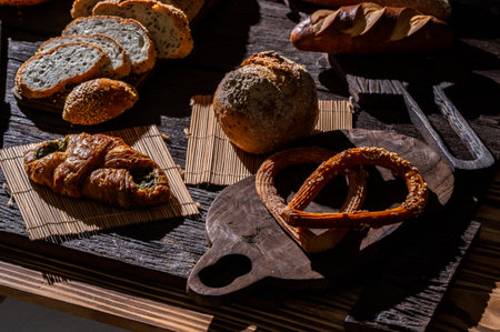 Different types of buns and pretzels on a wooden boardの写真素材